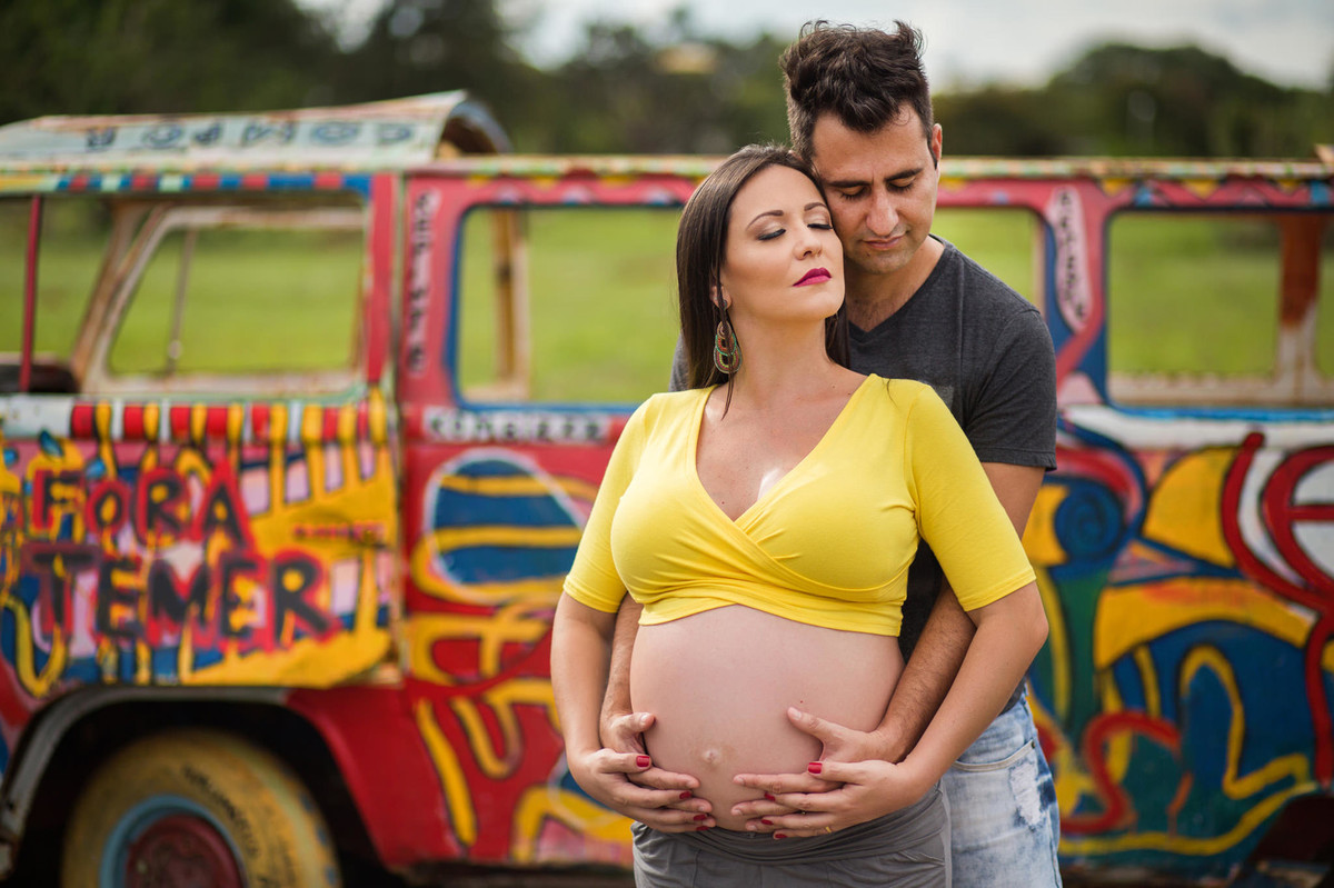Marido abraçando grávida com kombi no fundo. fotografia feita pelo fotógrafo de grávidas Rafael Ohana em Brasília