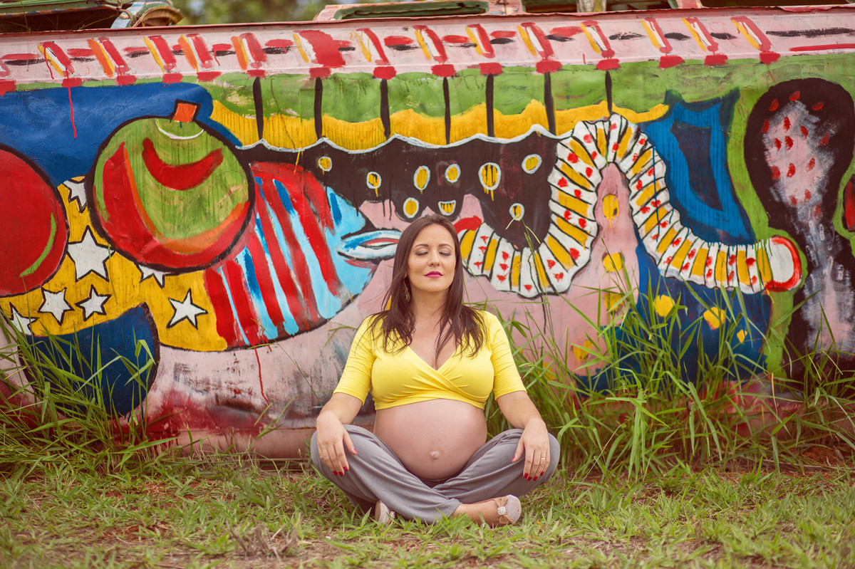 Grávida relaxando encostada em kombi colorida. fotografia feita pelo fotógrafo de grávidas Rafael Ohana em Brasília