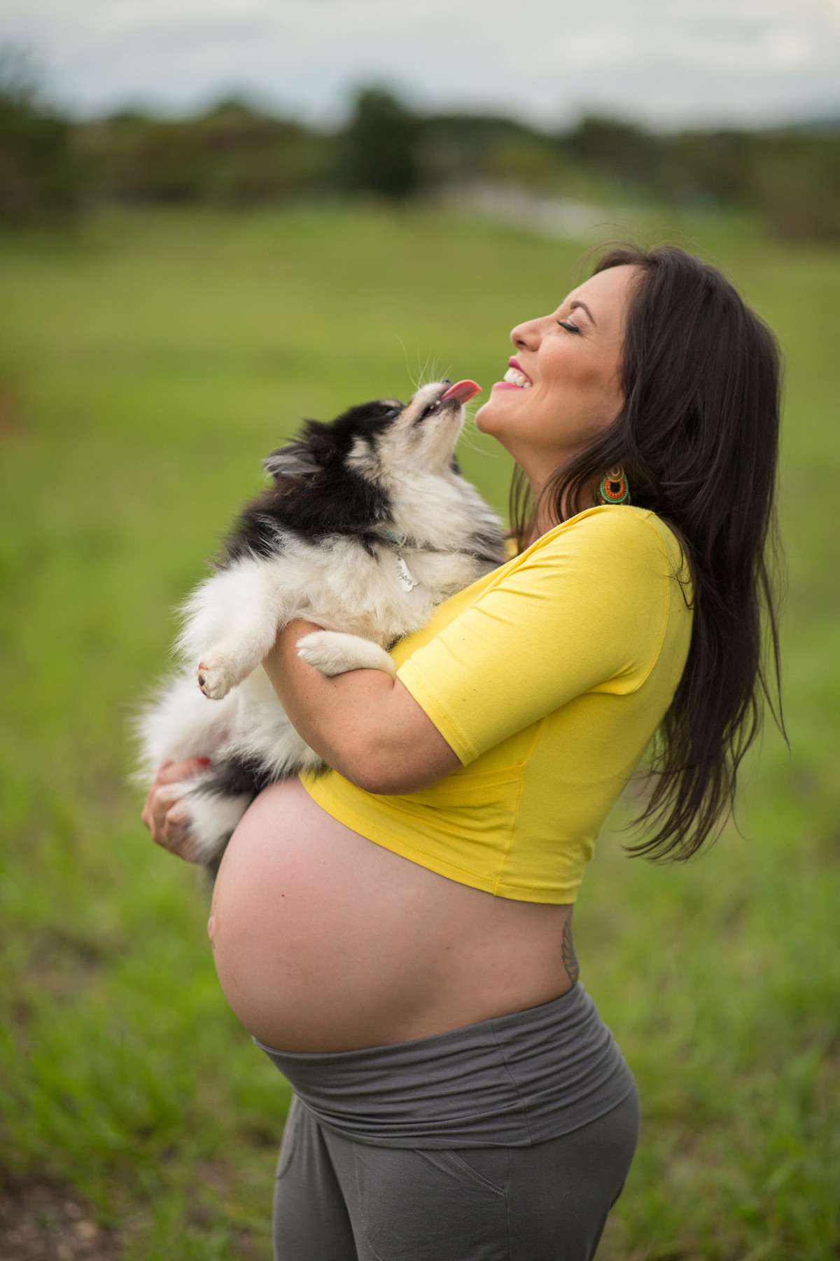 Grávida levando lambida do cachorro. fotografia feita pelo fotógrafo de grávidas Rafael Ohana em Brasília