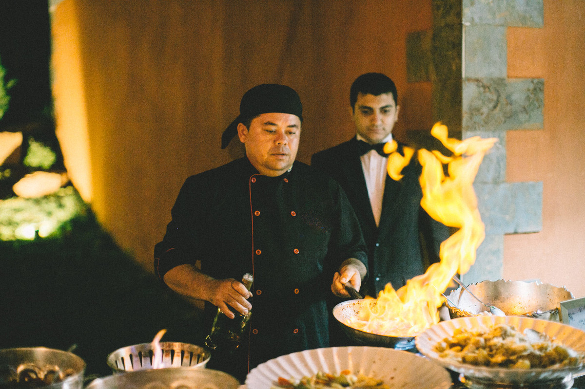 Chef de cozinha flambando camarões em recepção de casamento no Villa Giardini em Brasília-DF