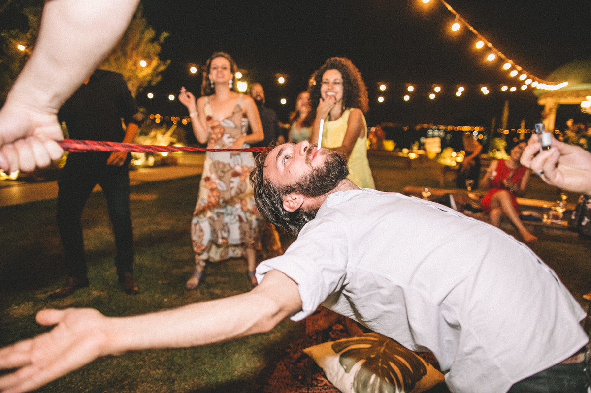 Convidado de casamento passando por debaixo da cordinha com cigarro na boca no Villa Giardini em Brasília-DF