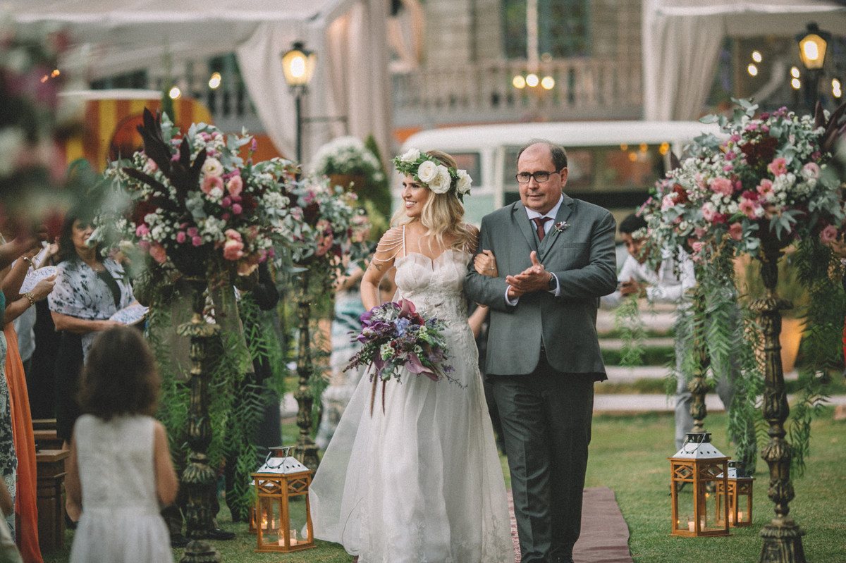 Noiva entrando em seu casamento sorrindo com seu pai no Villa Giardini em Brasília-DF