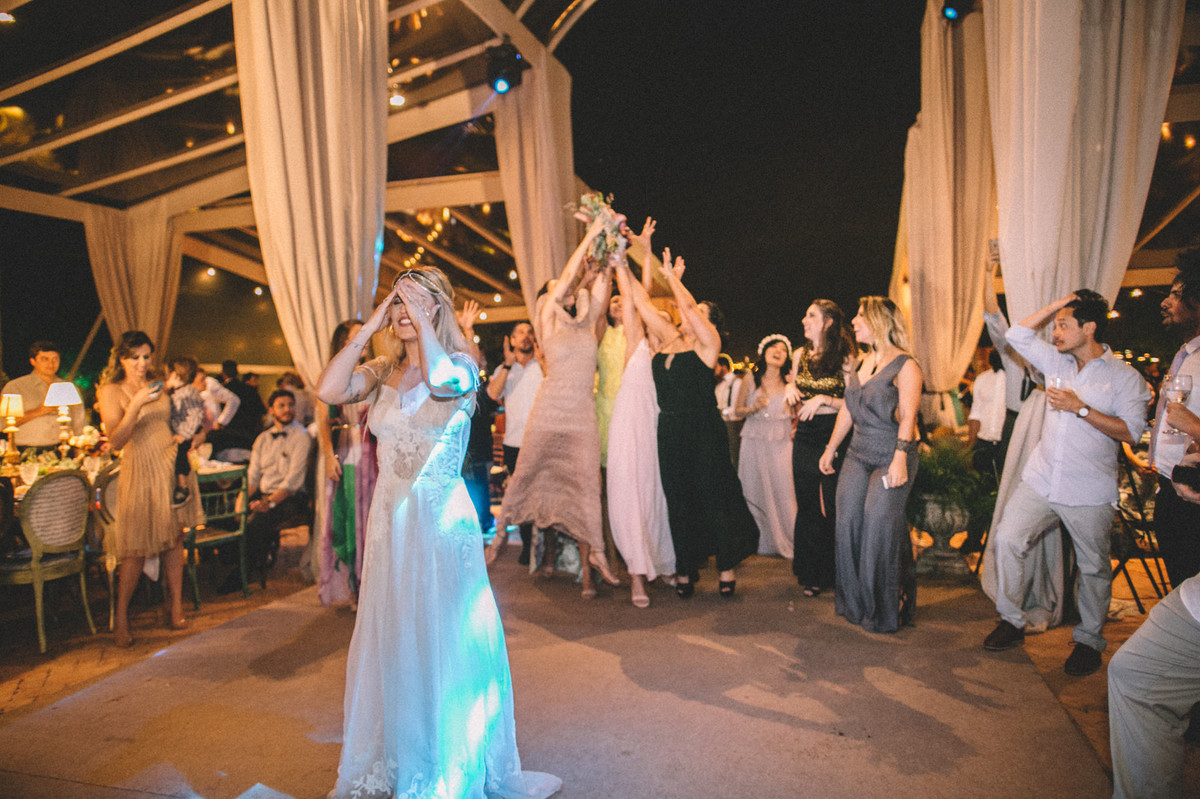Noiva jogando buquê para as solteiras em casamento no Villa Giardini em Brasília-DF