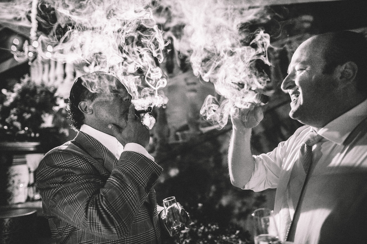 Padrinhos fumando charuto em casamento no Villa Giardini em Brasília-DF