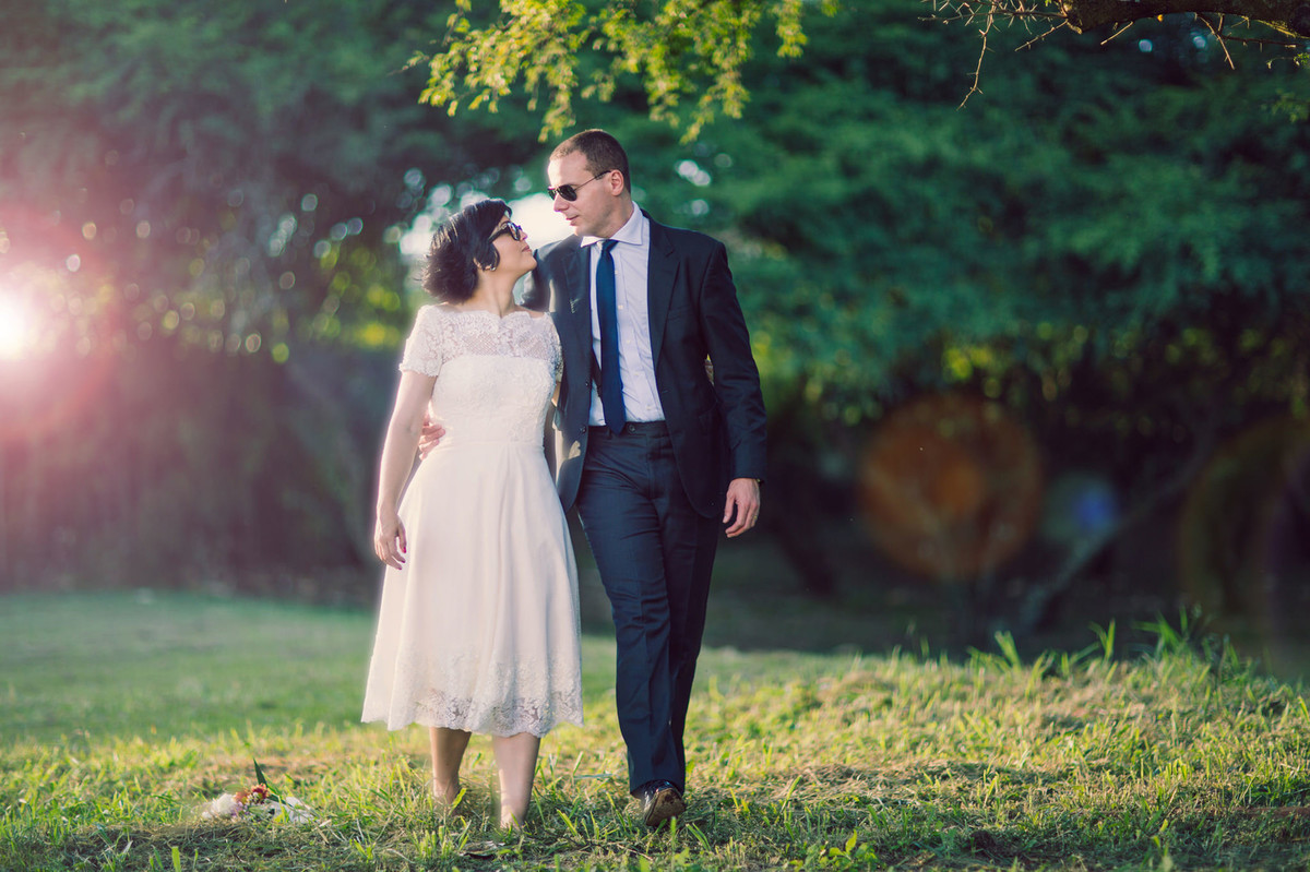 Casal andando abraçados pela floresta.