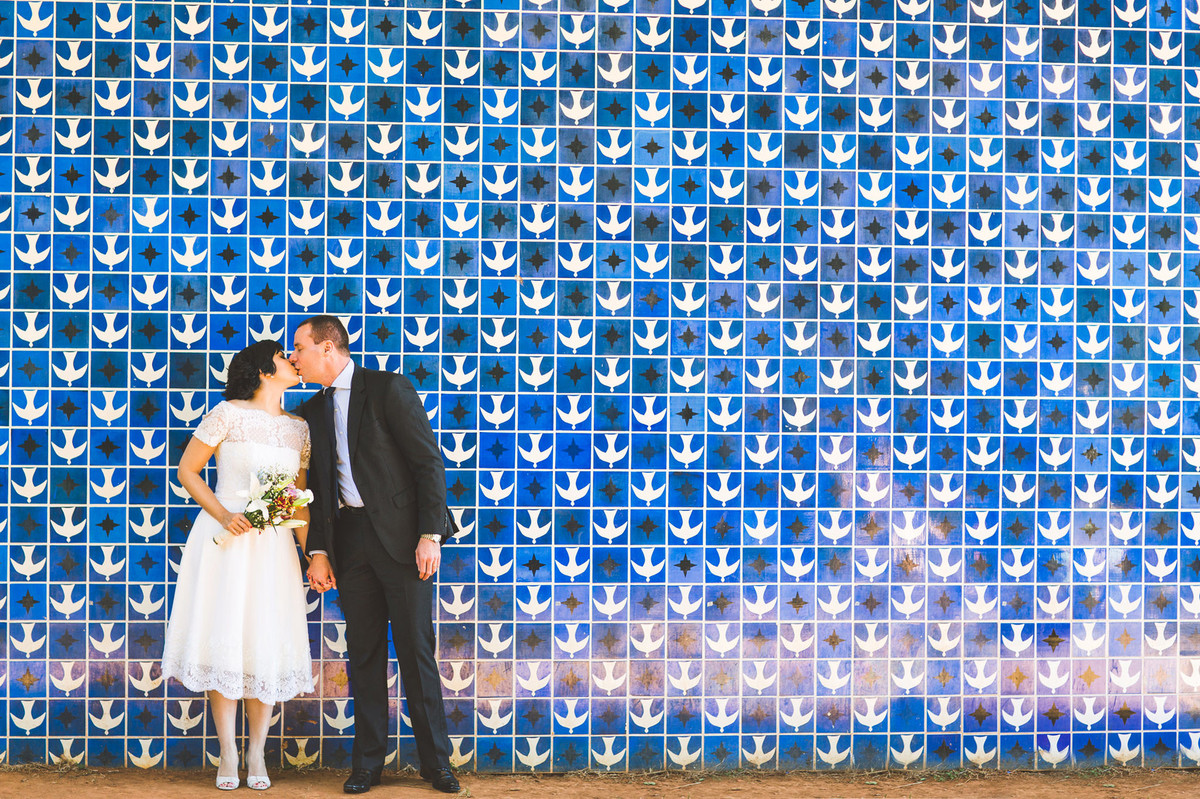 Casal vintage posando com azulejos Athos Bulcão na igrejinha da 307 sul em Brasilia. Fotografia pelo fotógrafo de casamento Rafael Ohana