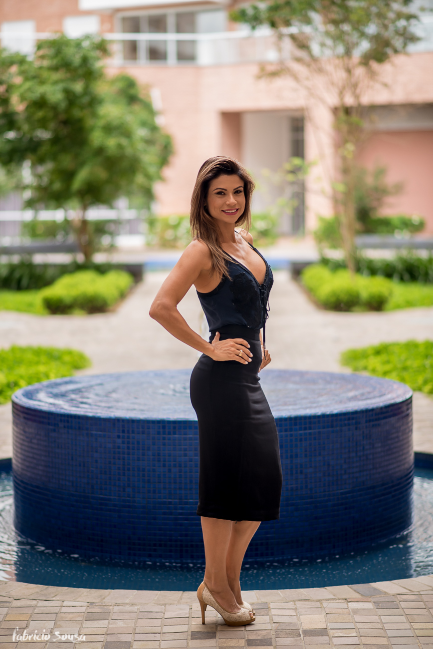Karina Peloi posa linda para fotografia em frente a fonte d'água