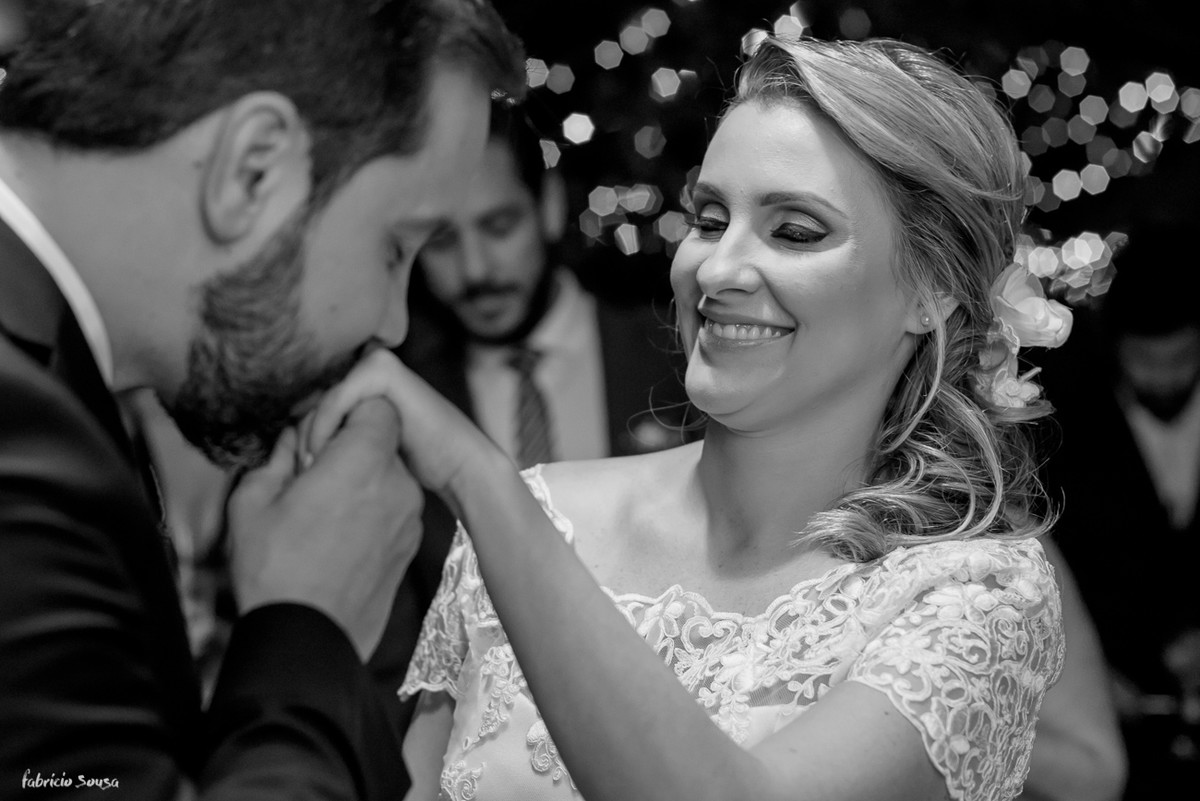 noivo beija a mão da noiva com aliança em seu mini-wedding - casamento na praia