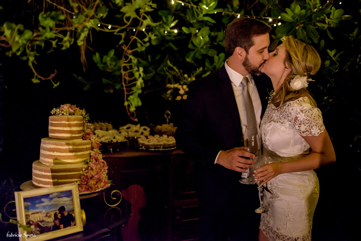 retrato do casal em beijo em frente a mesa de doces Bruna Doces com bolo Ana Petryna e decoração Casa Branca Eventos