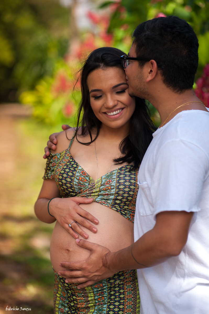 papai beija gravida segura barriga da mamãe gestante na sessão fotográfica no parque dos Igarapés em Bleém