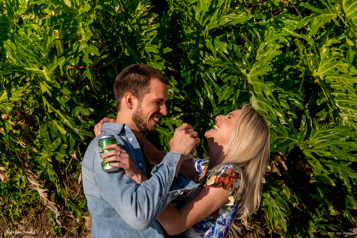 casal bebendo cerveja durante ensaio prewedding na praia