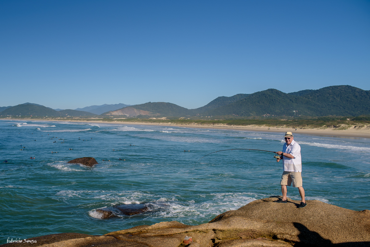 Damaceno se diverte enquanto pesca na praia da Joaquina