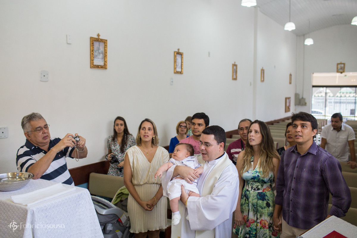 Padre segura o bebê no colo enquanto oram na igreja
