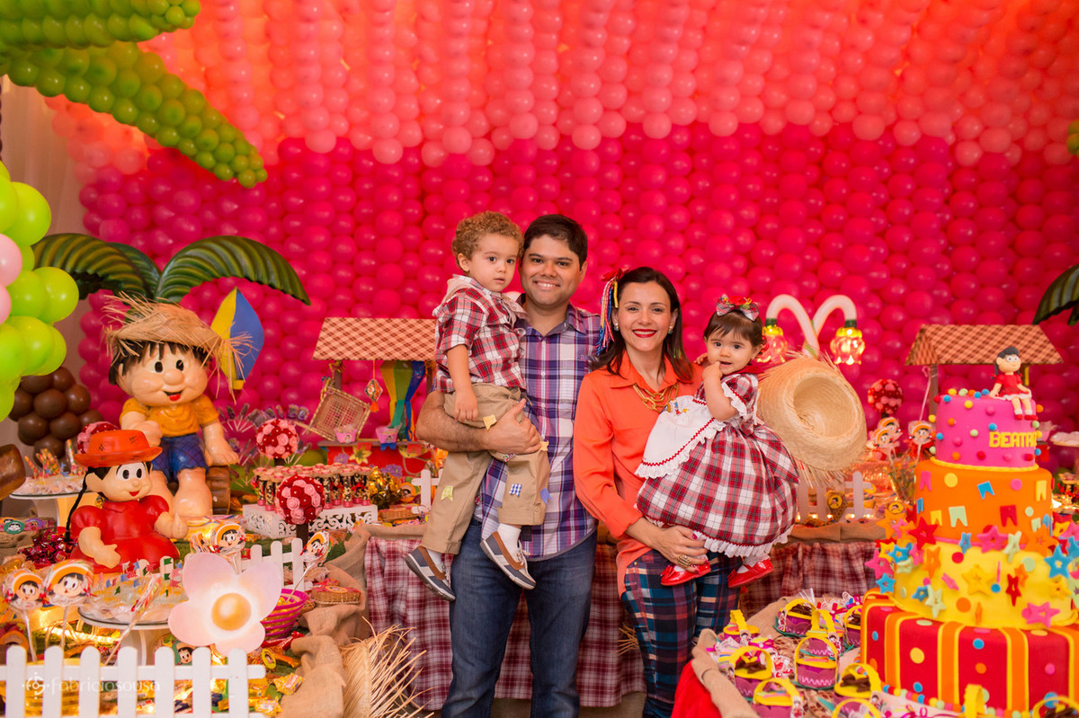 Retrato da família em frente a mesa de doces