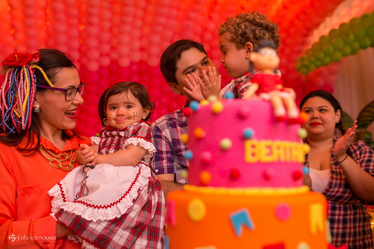 Mãe, aniversariante, pai e irmão atras do bolo
