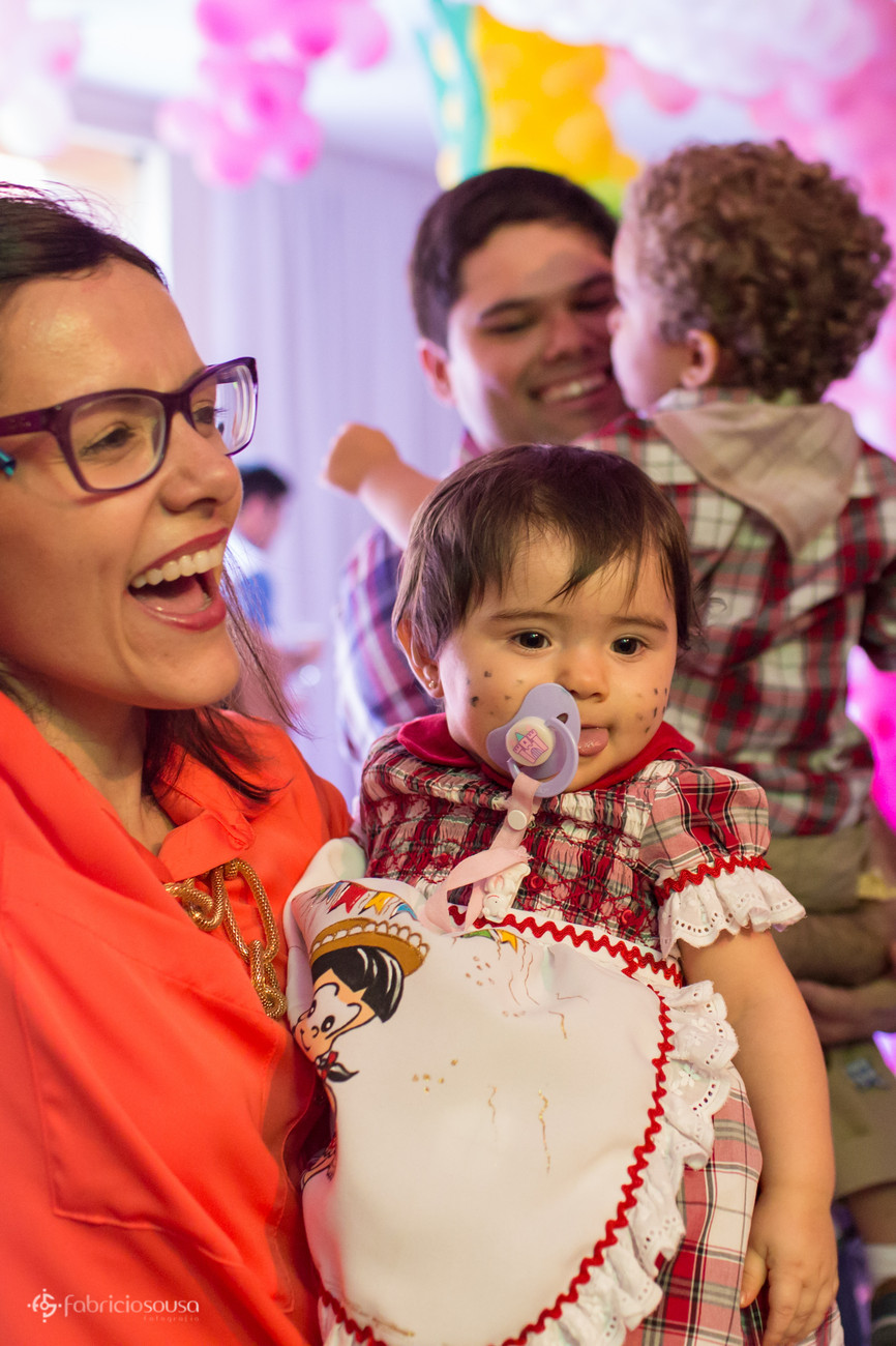 Mamãe com Bea no colo em primeiro plano e pai com filho no colo em segundo plano