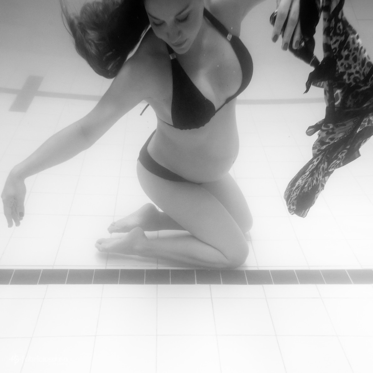 Mãe grávida no fundo da piscina p