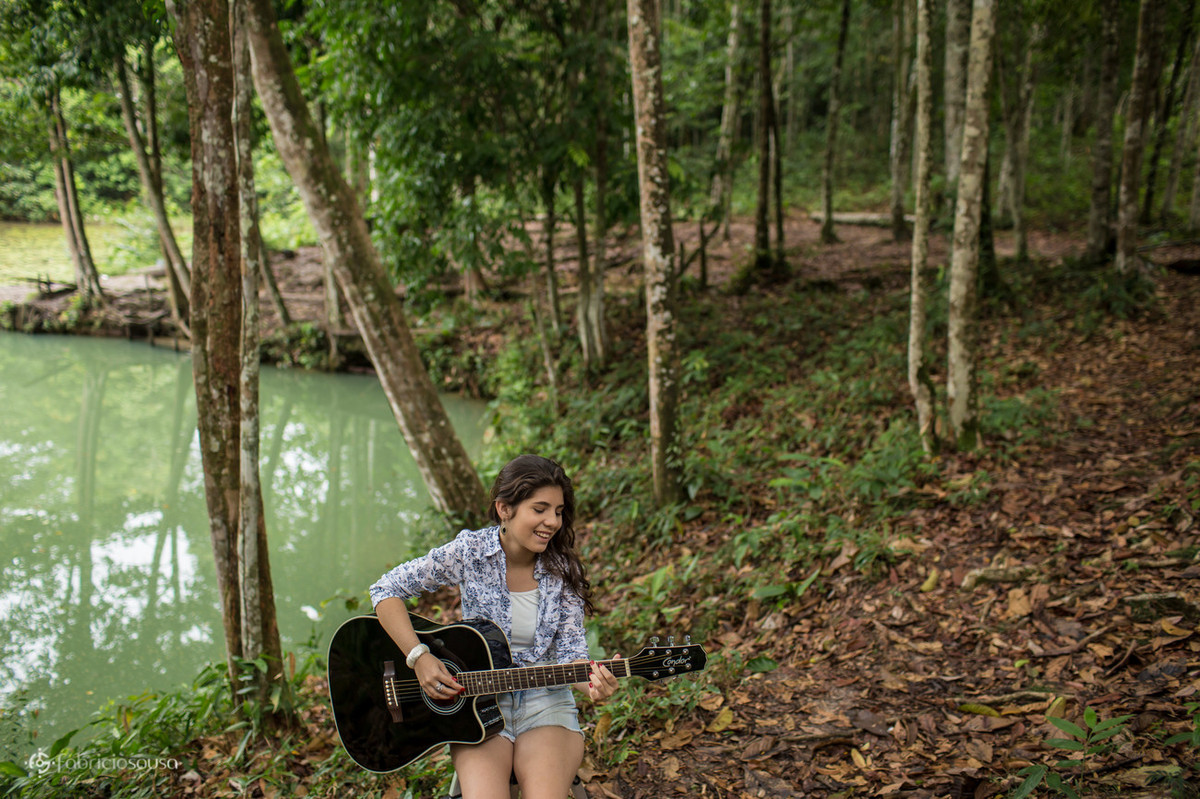 Aniversariante toca violão em meio a natureza do parque