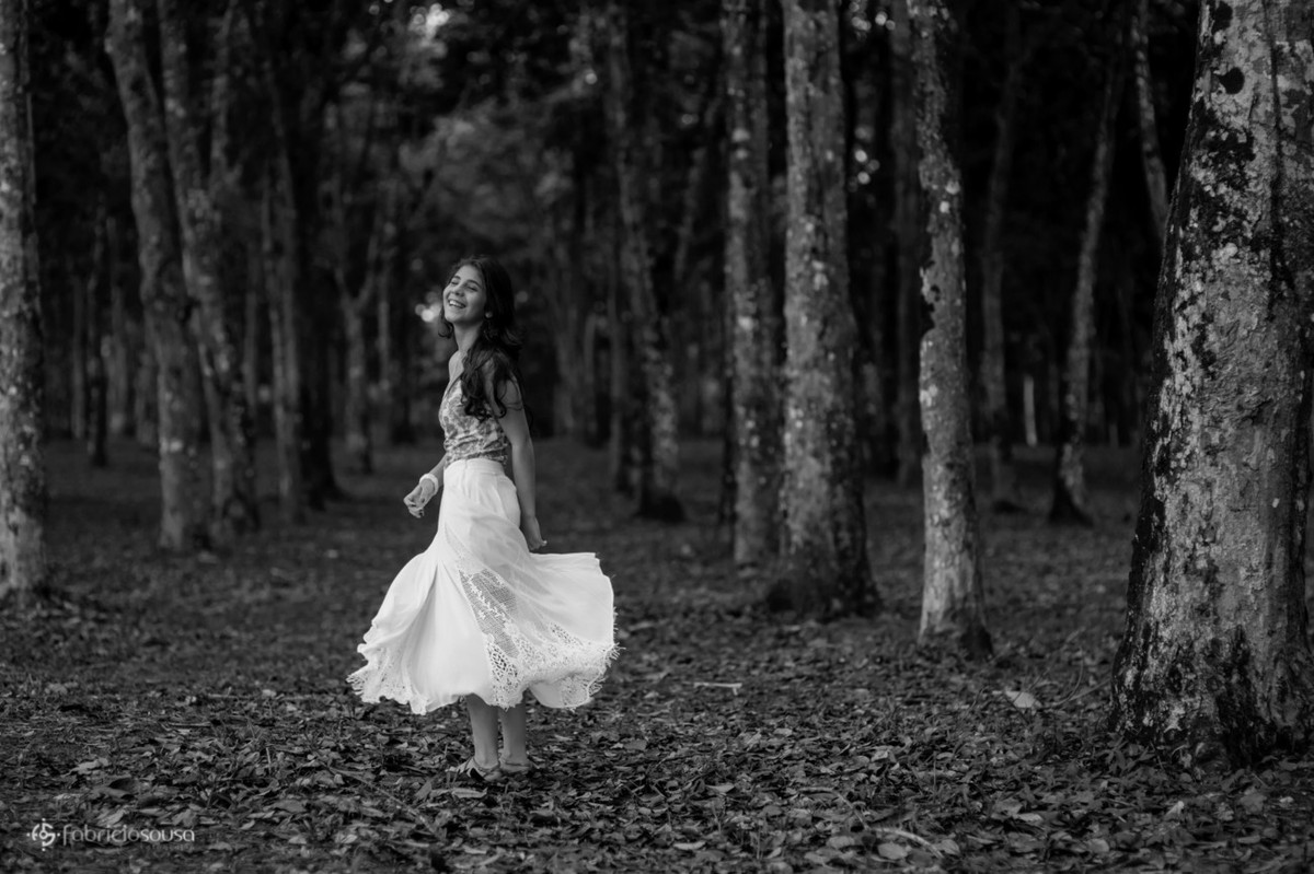 Debutante de vestido branco entre as árvores p