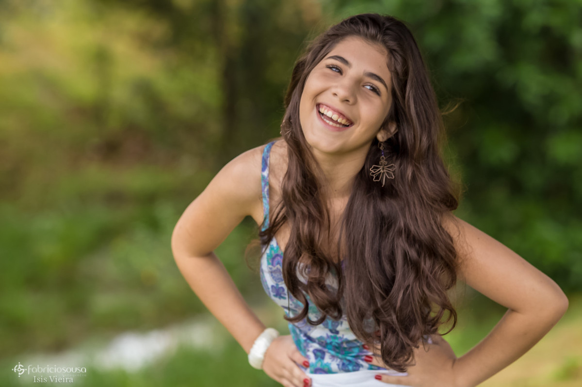 Ju sorridente com as mãos na cintura