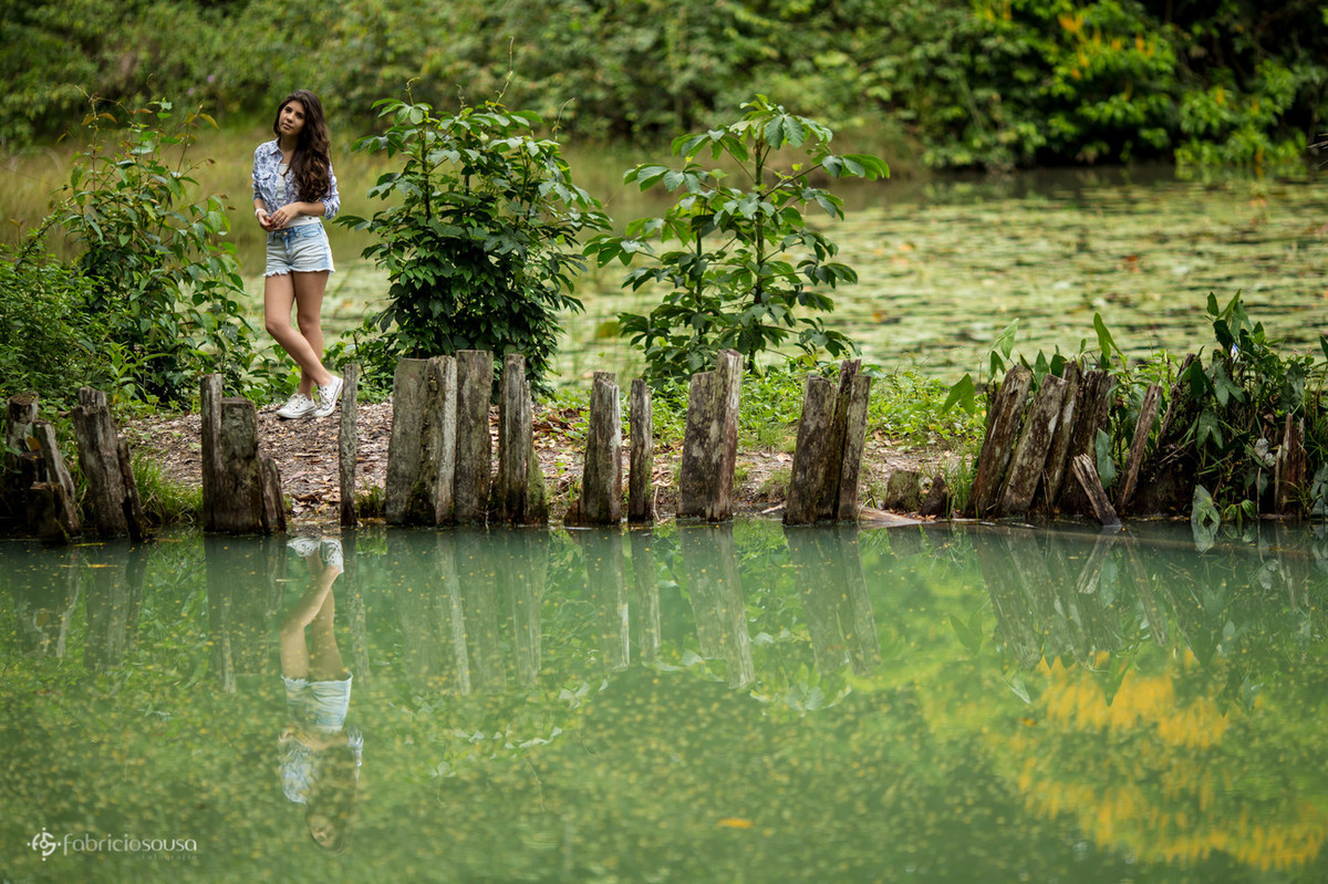 Linda jovem refletida na água do lago