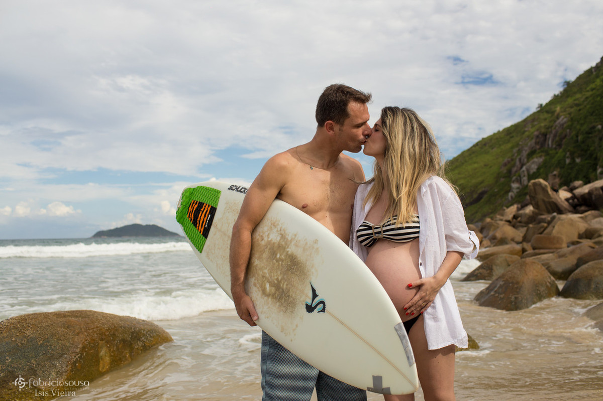 casal gestante surfista na beira do mar