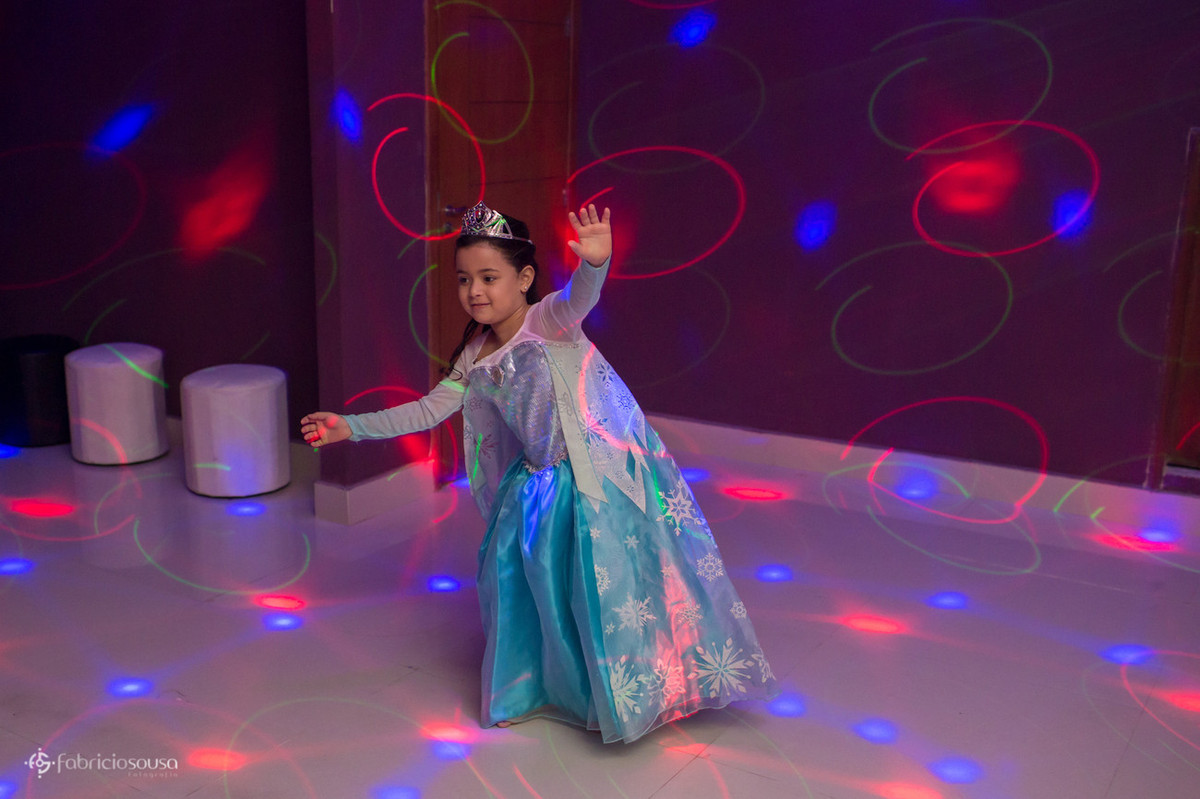 Menina com vestido de princesa dançando com as luzes do dj