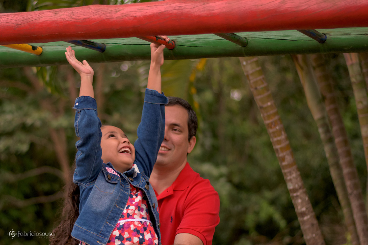 pai brincando com filha no parque