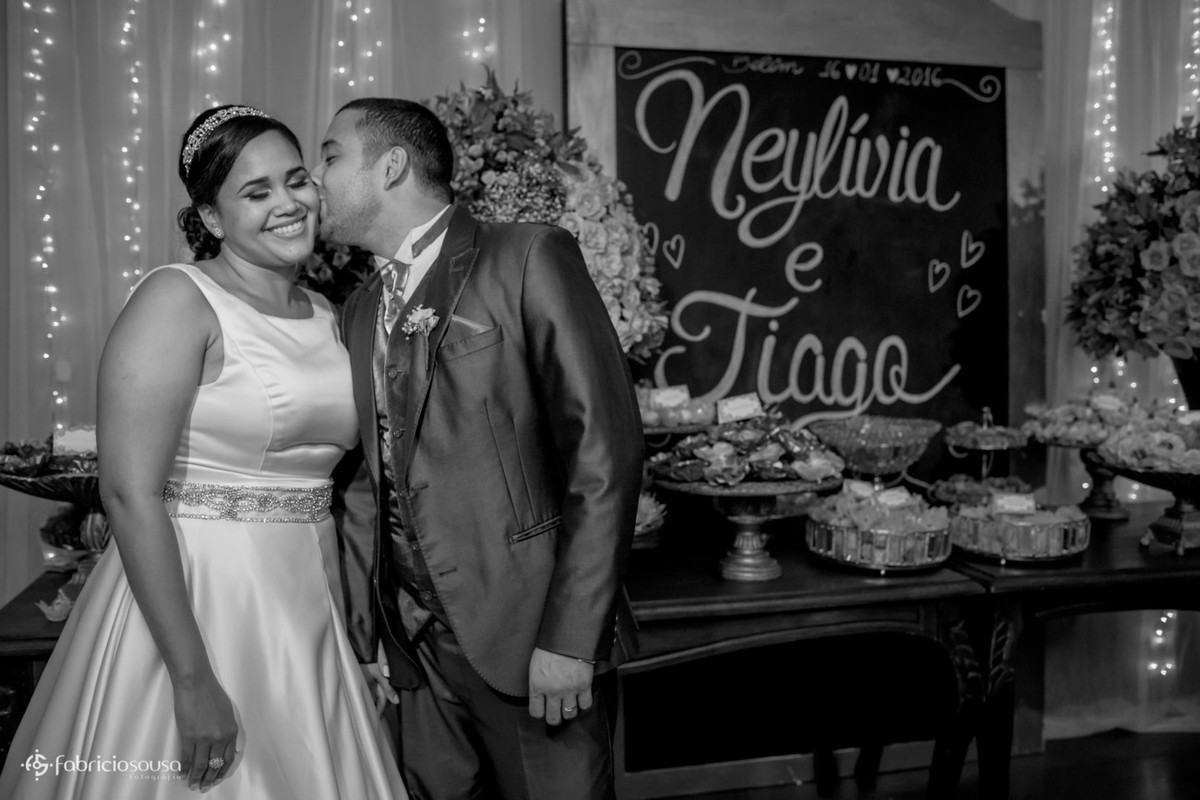 retrato do casal em frente a mesa de doces