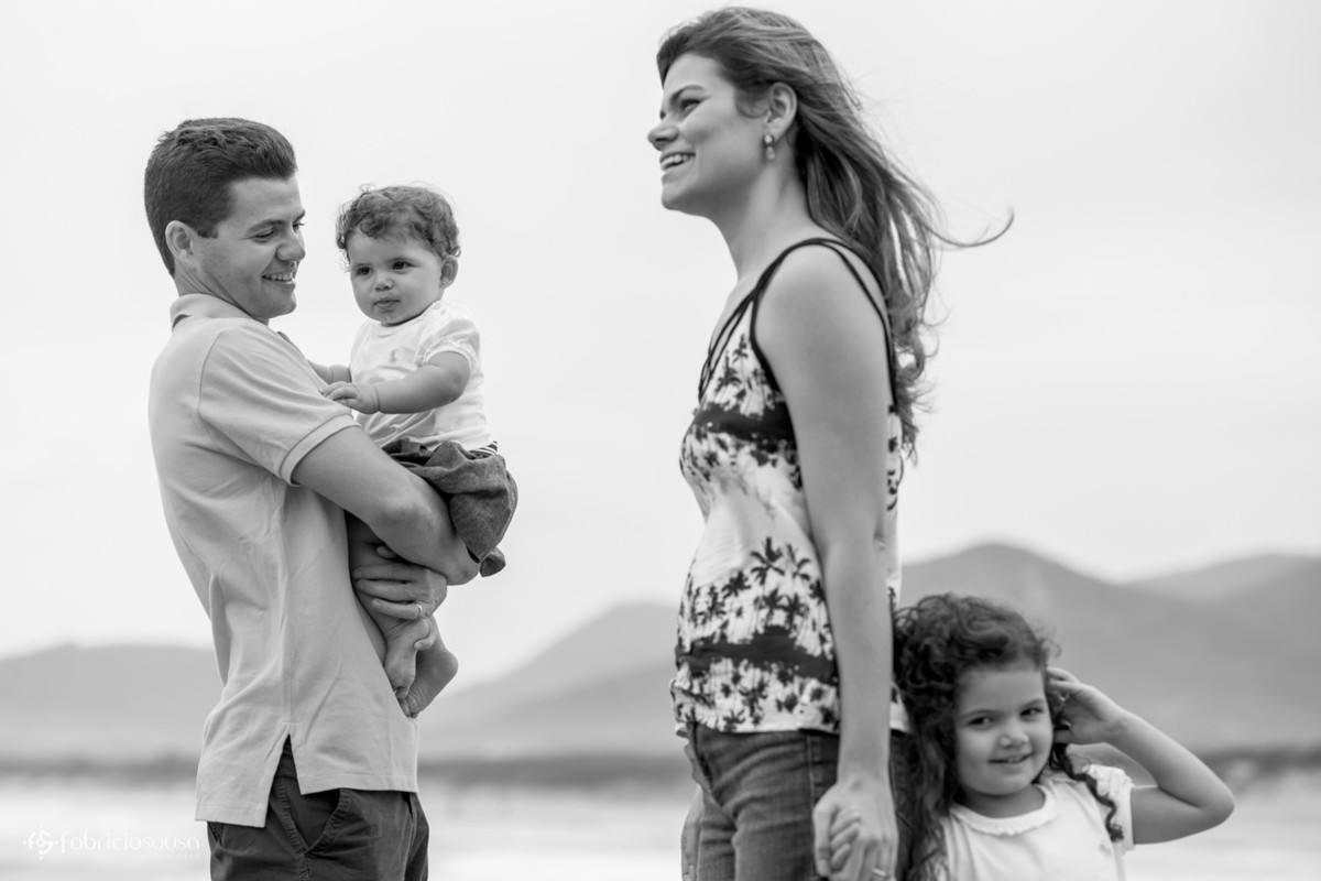 Pai com Maitê no colo e mãe de mãos dadas com Isabela bw