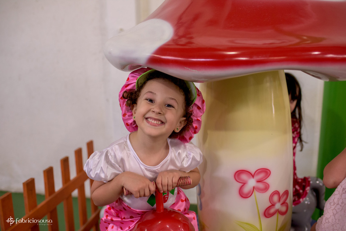 Maria Sofia de moranguinho sorrindo no parque