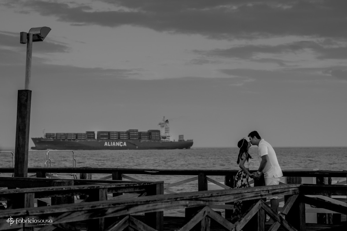 beijo do casal no trapiche com navio aliança no fundo