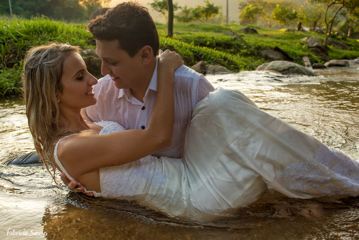 noivos se beijam dentro do rio em ensaio pos-casamento