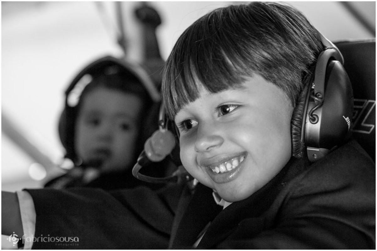 Irmãos pequenos utilizam os head sets do avião p