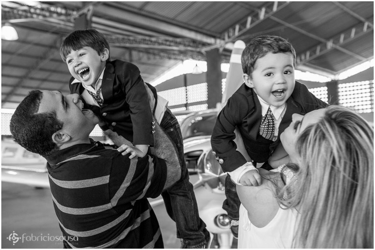 Pai e mãe erguem seus filhos para cima black and white