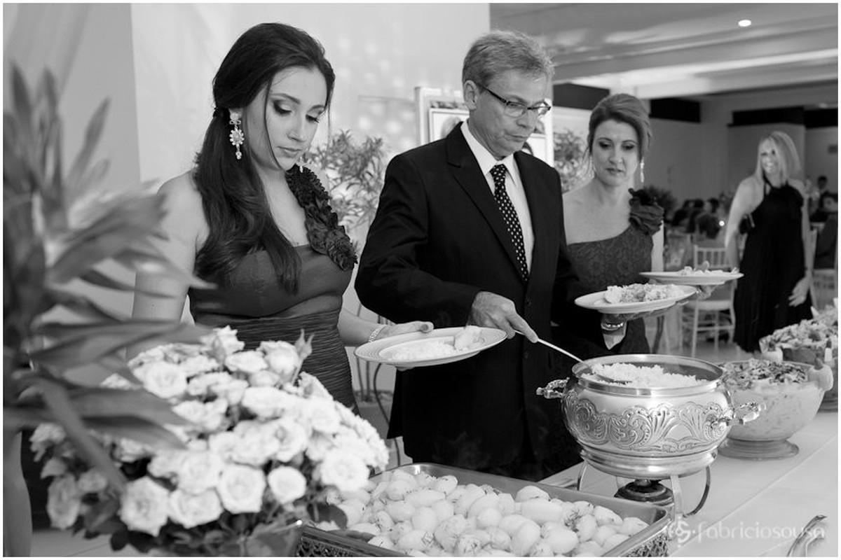 Formanda e os pais se servem para o jantar
