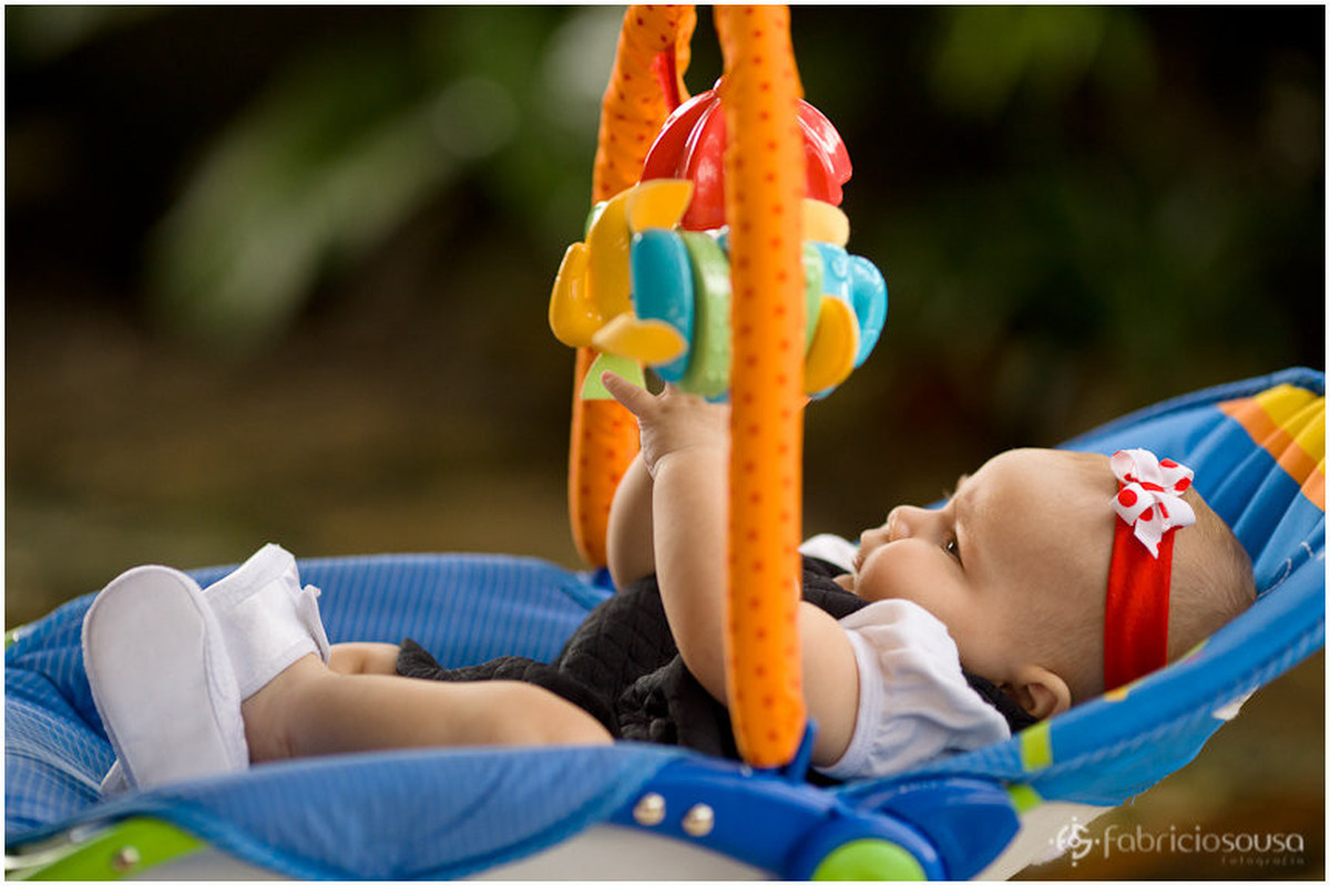 Menininha se distrai com brinquedos na cadeirinha