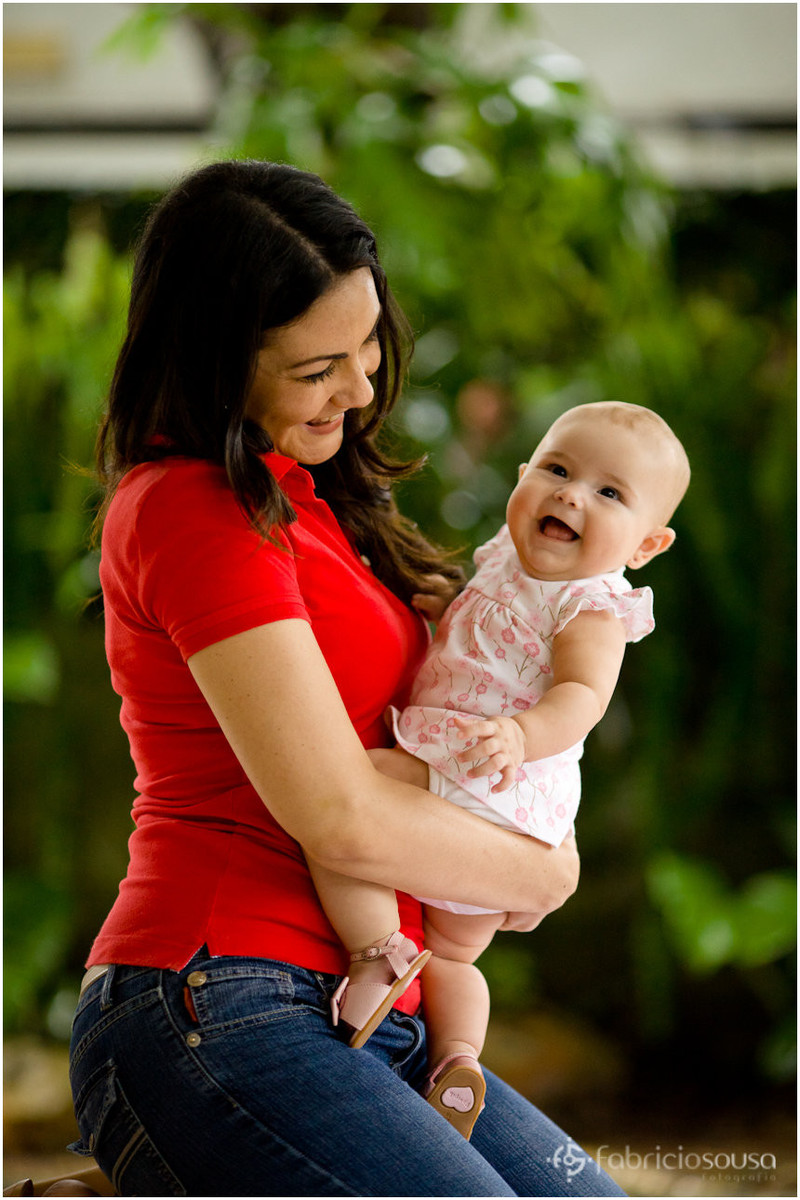 Mamãe com a filha risonha no colo