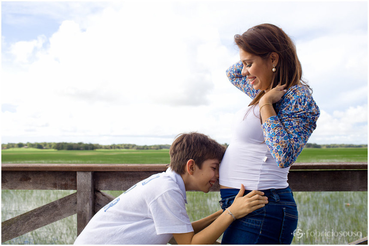 Irmão mais velho faz carinho na barriga da mãe