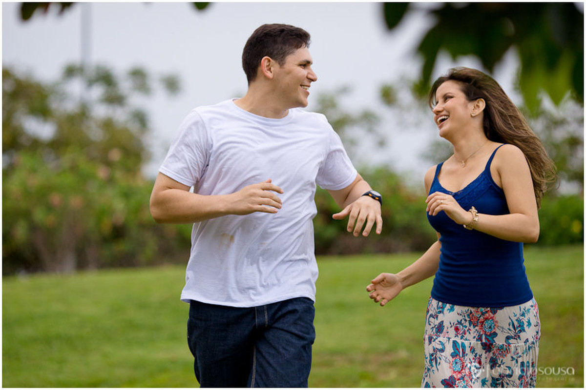 Casal corre sorridente pelo gramado