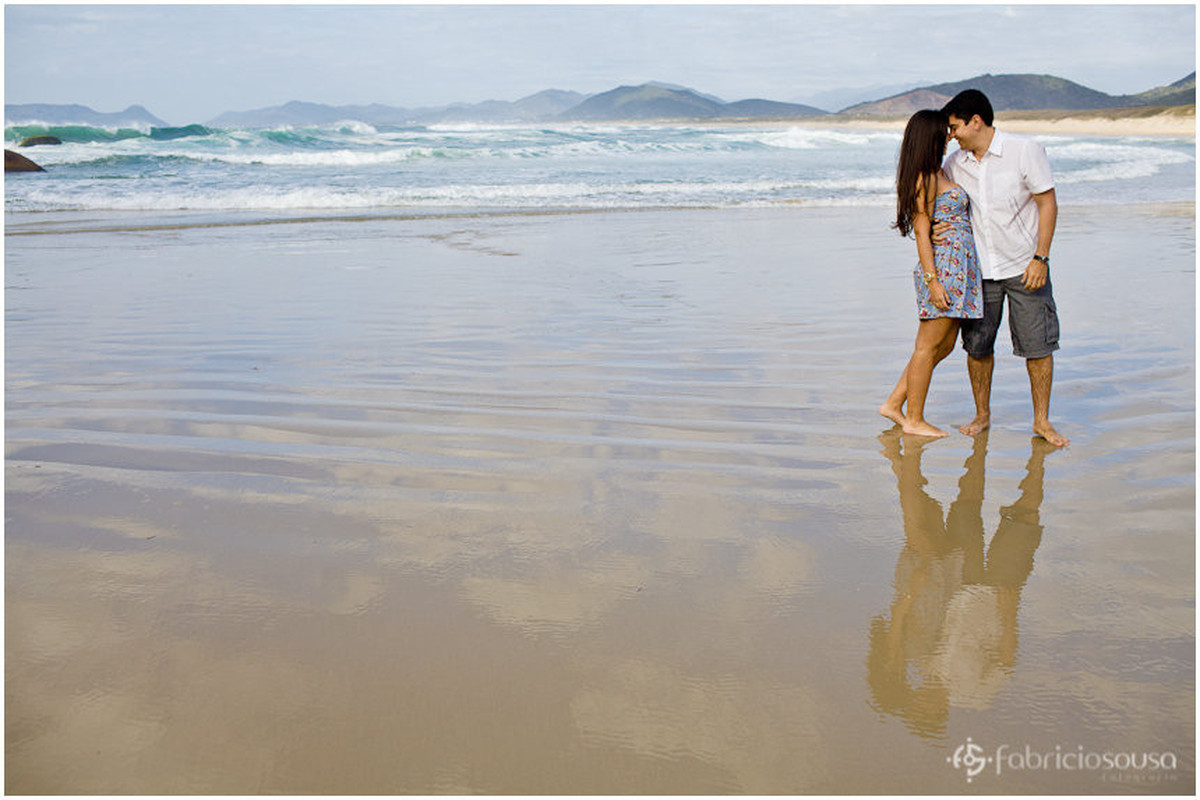 reflexo do casal na areia molhada da praia da Joaquina logo de manhã cedo