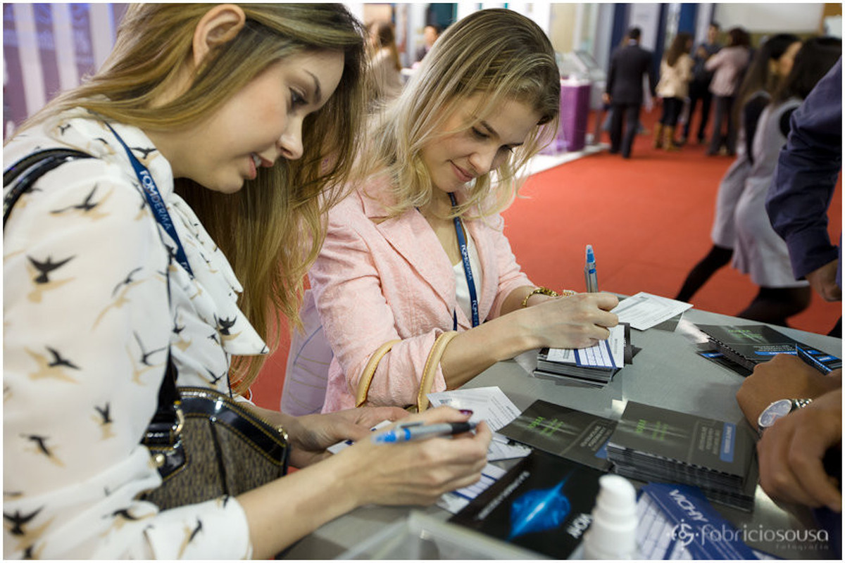 Duas participantes do congresso preenchendo formulário