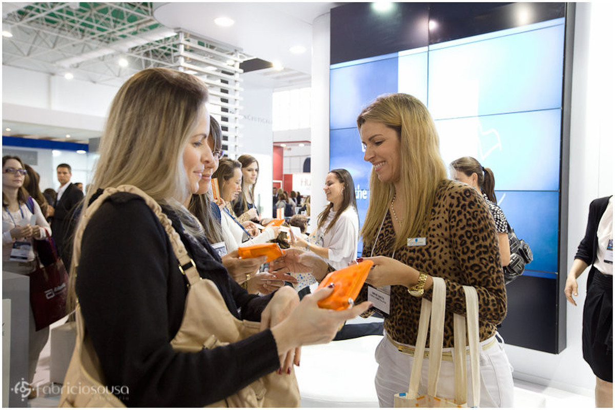 Participantes do congresso de dermatologia recebendo brindes da L'oréal