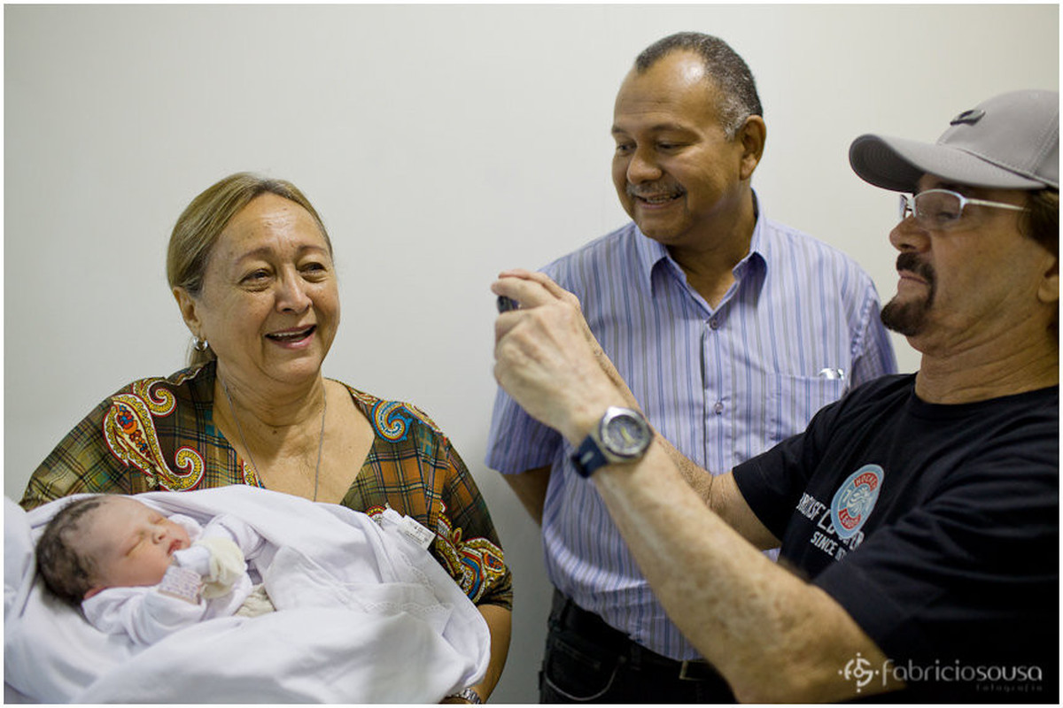 Familiares e parentes tirando fotos com a bebê