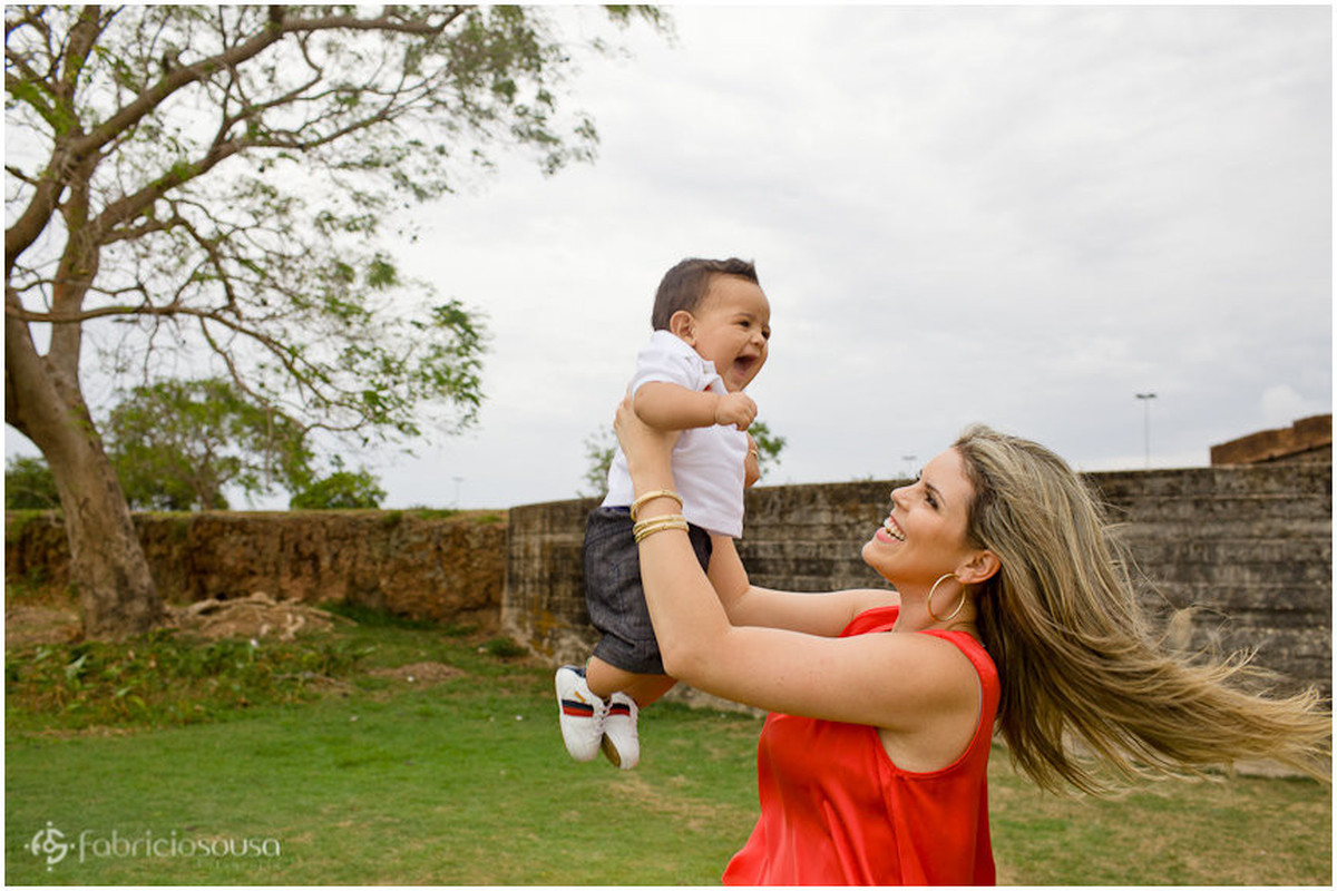 mãe levanta o filho pro alto em sessão fotográfica