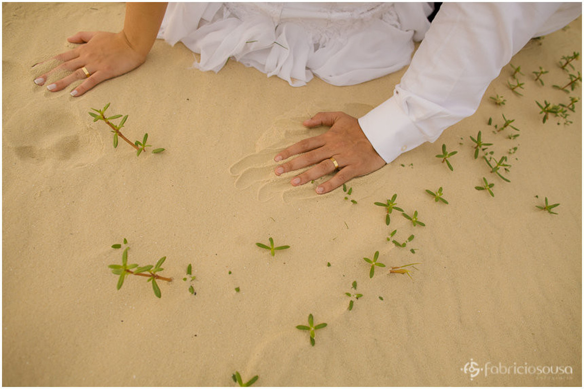 detalhes das mãos na areia durante trash the dress