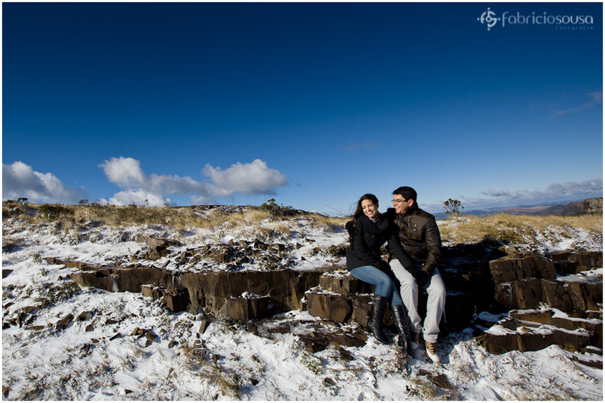 casal sentado na pedra com neve no morro da Igreja