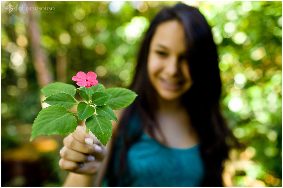 Foco na flor que a jovem de 15 anos segura