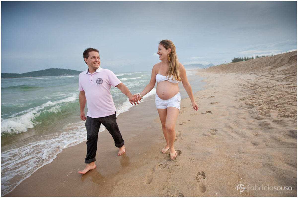 casal caminhando na praia - mãe grávida de 8 meses