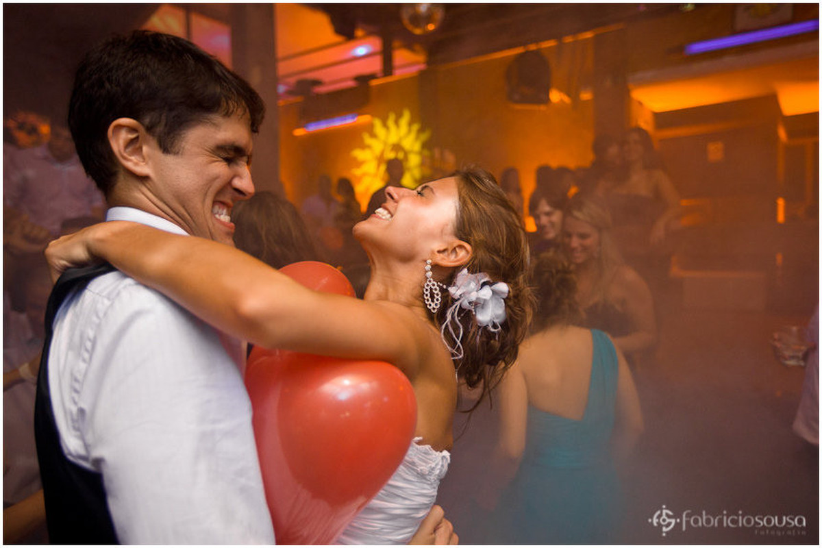 noivos tentando estourar balão de coração vermelho